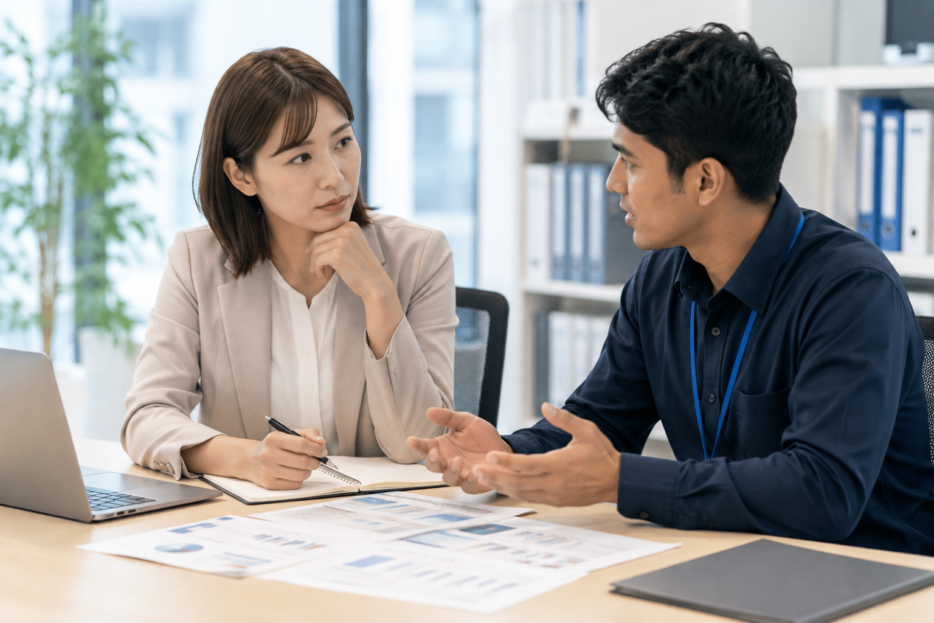 外国人社員と仕事内容を確認する企業担当者